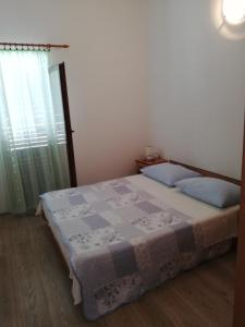 ein Schlafzimmer mit einem Bett mit einer Decke darauf in der Unterkunft Apartman Dino in Murter