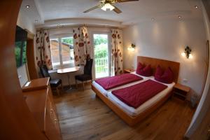 a bedroom with a large bed with red sheets at Seebär Velden in Velden am Wörthersee