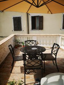 patio con tavolo, sedie e ombrellone di Apartma Na terasi a Izola