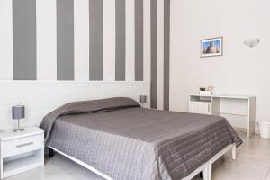 una camera con letto e parete a righe di Hotel Costanza a Catania