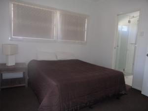 多尔比Windsor Hotel Motel Dalby的一间带床、窗户和桌子的卧室