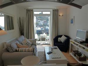 a living room with a couch and a table at Polmear Harbour View With Terrace in Looe