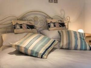 a bed with two pillows on top of it at Polmear Harbour View With Terrace in Looe