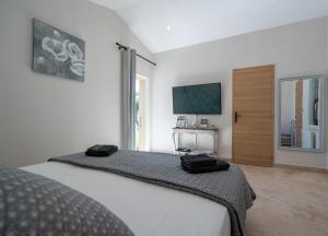 ein Schlafzimmer mit einem Bett mit zwei schwarzen Säcken darauf in der Unterkunft Mas la Chêneraie Lourmarin - Au calme, à 10 mn du centre ville à pied in Lourmarin