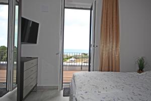 a bedroom with a bed and a television and a balcony at Villa Düne -Penthousewohnung WE 18 in Baabe