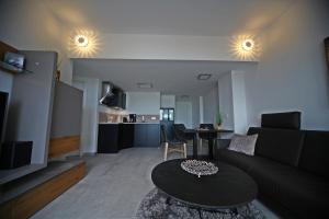 a living room with a black couch and a table at Villa Düne -Penthousewohnung WE 18 in Baabe