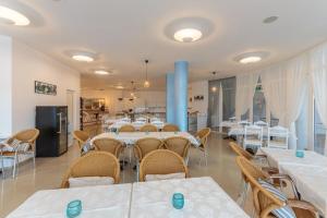 a dining room with white tables and chairs at DEA Pasavan Apartments in Ravda