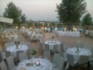 uma recepção de casamento com mesas e cadeiras brancas e velas em Acropol Hotel em Serres