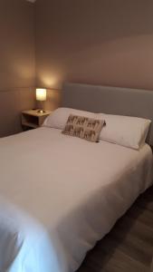 a large white bed in a room with a lamp at Suzies Self Catering Belmont in Belmont