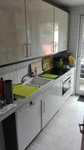 a kitchen with white cabinets and a sink at Ferienwohnung Kück-Rathausstrasse in Hahnenklee-Bockswiese