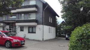 a red car parked in front of a house at Ferienwohnung Kück-Rathausstrasse in Hahnenklee-Bockswiese
