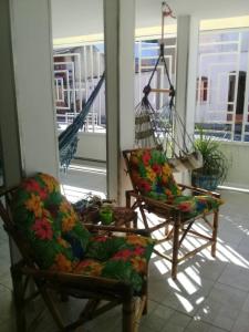 dos sillas sentadas en un porche junto a un columpio en Pousada Formosa, en Porto Seguro