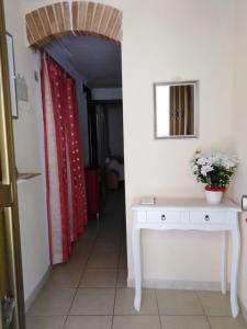 薩索迪卡斯塔爾達的住宿－Casa Vacanze Margherita - Sasso di Castalda，走廊上设有白色桌子和红色窗帘