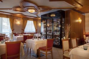 安達洛的住宿－Adler Hotel Wellness & Spa - Andalo，一间带桌椅的餐厅和一个酒窖