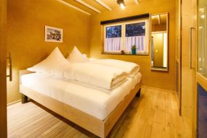 a bedroom with a bed with white sheets and a window at Blaues Haus in Monschau +11 photos