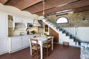 a kitchen with a table and a spiral staircase at Fattoria Pogni in Marcialla