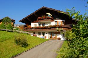 une maison sur une colline avec des boîtes de fleurs sur elle dans l'établissement Landhaus Wild, à Riezlern