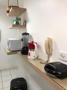 um balcão de cozinha com um telefone e um liquidificador em Apartamentos Praia de Pajucara em Maceió