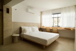 a bedroom with a white bed and a window at City Centre Rooms in Limassol