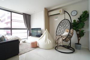 Habitación con una silla colgante en la sala de estar. en Prairie Villa en Ban Khlong Ta Khet