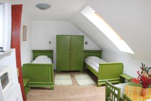 two beds in a room with green cabinets at Őrszem Fogadó in Szalafő