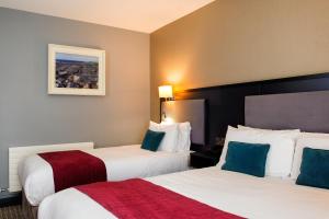 una habitación de hotel con 2 camas y un cuadro en la pared en Cliffs of Moher Hotel en Liscannor