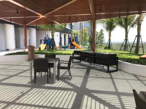 a patio with a table and chairs and a playground at Almas Suites Puteri Harbour in Nusajaya