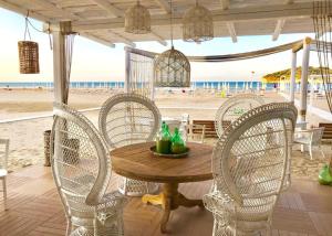 een houten tafel en stoelen op het strand bij Hotel Gargano in Vieste