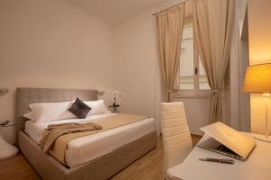 een slaapkamer met een bed en een bureau met een laptop bij Domus Veneto Rome in Rome
