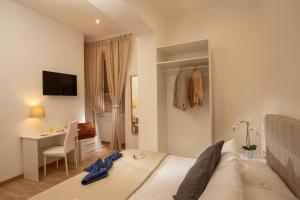 een witte slaapkamer met een bed, een bureau en een tafel bij Domus Veneto Rome in Rome
