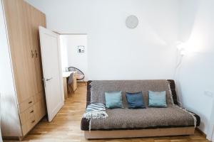 ein Sofa in einem Zimmer mit blauen Kissen darauf in der Unterkunft Krakivska 24 in Lwiw