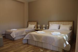 a room with two beds with white sheets at Emis Hotel in Tbilisi City