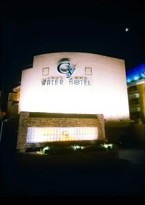 ein Schild vor einem Wasserturm in der Nacht in der Unterkunft WATER HOTEL Cy (Audlt Only) in Machida