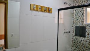 a bathroom with a shower and a mirror at Hotel Casa Ocarina in São Paulo