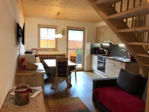 cocina y sala de estar con mesa y sofá en Appartement Leirer en Alpbach