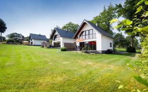 une maison avec une grande pelouse devant elle dans l'établissement Graues Haus, à Monschau