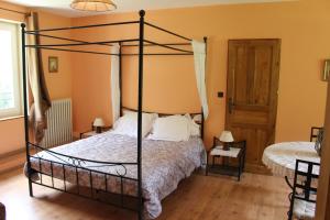 1 dormitorio con cama con dosel y ventana en Moulin de Bray - Chambres d'hotes et hébergement Insolite, en Vieux-Vy-sur-Couesnon