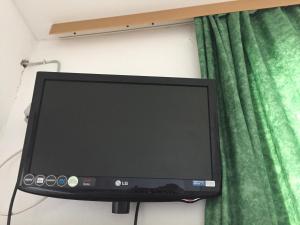 a computer monitor sitting on a wall next to a green curtain at Lovely apartman Ana Sucuraj in Sućuraj