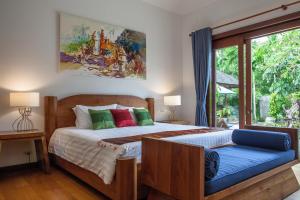 a bedroom with a bed and a large window at Baan Pinya Balinese Style Pool Villa in Krabi town