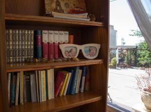 un estante de libros con libros y fotos. en The Holy Rock - Hostel at meteora, en Kalambaka