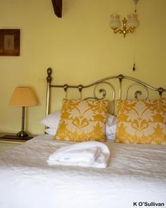 a bed with a white comforter and pillows at The New Inn in Crediton
