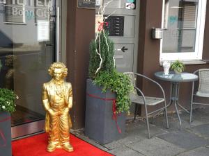 una statua d'oro su un tappeto rosso di fronte a un negozio di Hotel Bonn City a Bonn