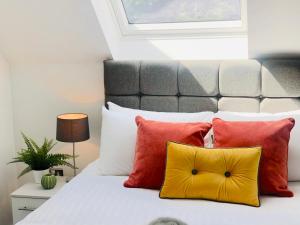 a bedroom with a bed with red and yellow pillows at Shield Penthouse Loft - 2 Bedroom Luxe Large Apartment in Sheffield