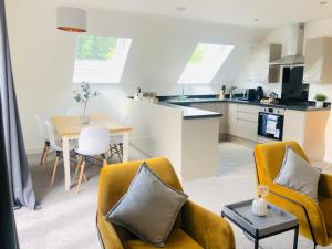 a kitchen and living room with yellow chairs and a table at Shield Penthouse Loft - 2 Bedroom Luxe Large Apartment in Sheffield