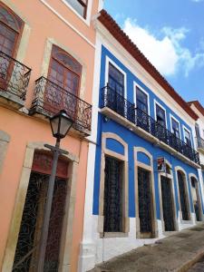 a blue and pink building with a street light in front at Pousada Portas da Amazônia in São Luís