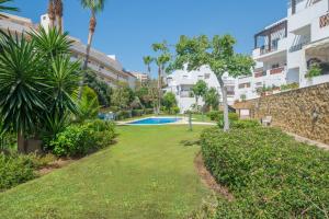 un jardín con piscina en un edificio en Sea Flower Beach & Golf II parking included, en Mijas Costa