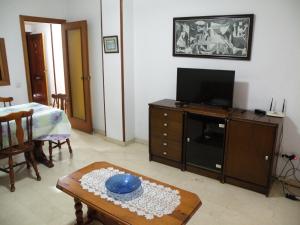 a living room with a tv and a table at Los Pinos - Fincas Arena in Benidorm