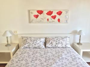 um quarto com uma cama com rosas vermelhas na parede em Tricesimo Apartment em Tricesimo