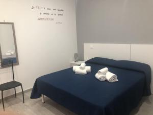 a bedroom with a blue bed with towels on it at La Ruota B&B in Terrasini