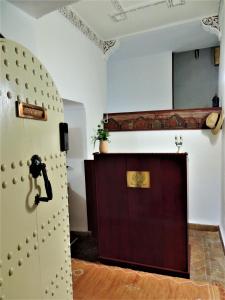 Habitación con puerta y espejo en la pared. en Riad Tizgui Celine en Marrakech